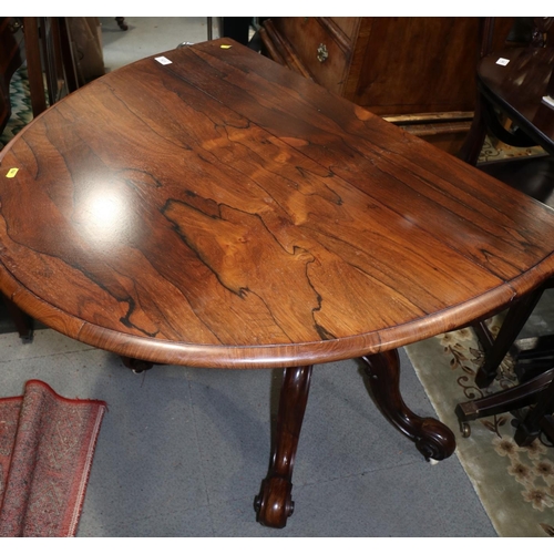 425 - A 19th century rosewood oval drop leaf table, on folding quadruple scroll supports, 36