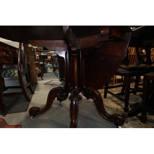 425 - A 19th century rosewood oval drop leaf table, on folding quadruple scroll supports, 36