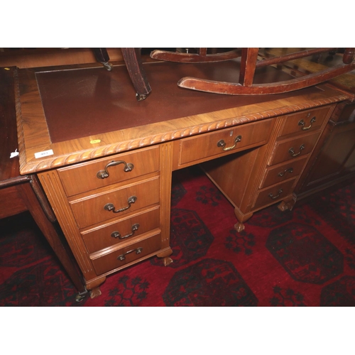 483 - A mid 20th century carved walnut double pedestal desk with tooled lined top over nine drawers, on ca... 