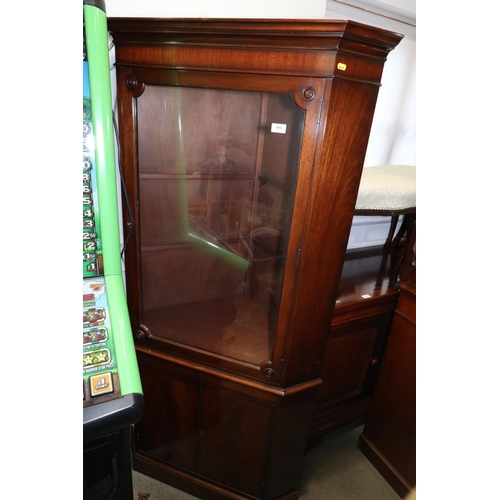 491 - A mahogany corner display cabinet, the upper section enclosed glazed panel door over cupboard, on bl... 