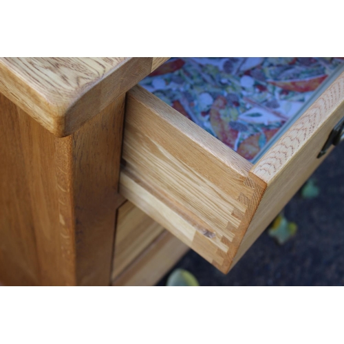 534 - A light oak sideboard/chest of drawers, fitted three small drawers over four long drawers, on stile ... 