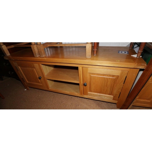 553 - A modern light oak television stand/sideboard, fitted central recess flanked by cupboards, on square... 