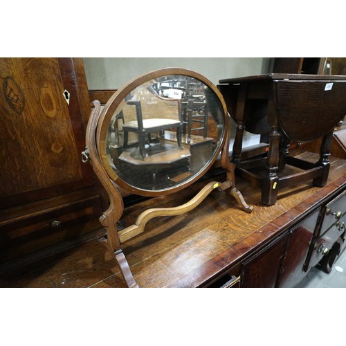 564 - A mahogany skeleton toilet mirror with oval bevelled plate, 16 1/2