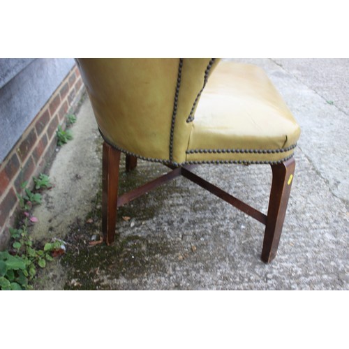 490 - A studded armchair, upholstered in a mustard leather, on stained as walnut cross stretchered support... 