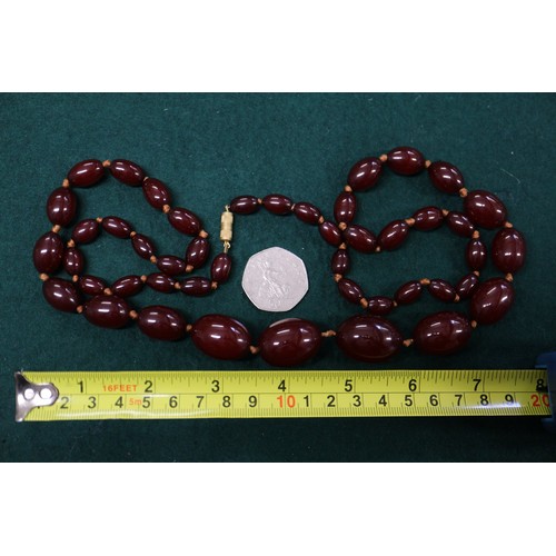 301 - A cherry amber Bakelite bead necklace, the largest oval bead, 27mm long, 68.5g gross