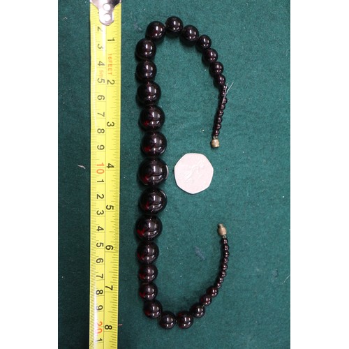 304 - A cherry amber Bakelite round bead necklace, the largest bead, 20mm dia, 42.2g gross, and a similar ... 