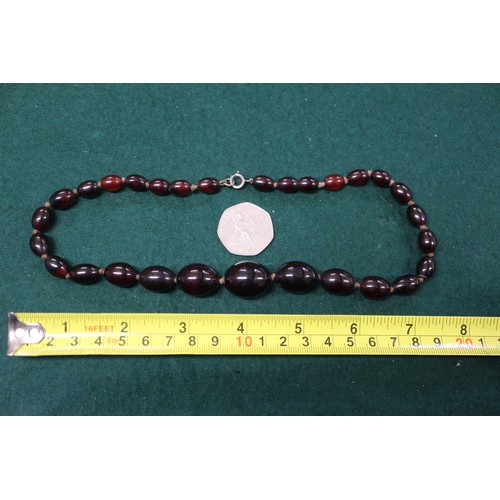 304 - A cherry amber Bakelite round bead necklace, the largest bead, 20mm dia, 42.2g gross, and a similar ... 