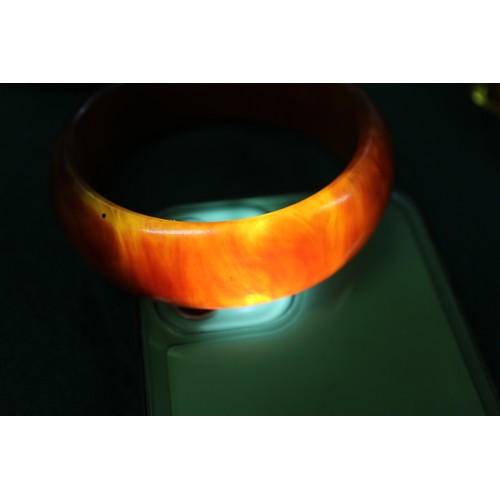 292 - A collection of amber Bakelite bangles and bracelets, 280.4g gross