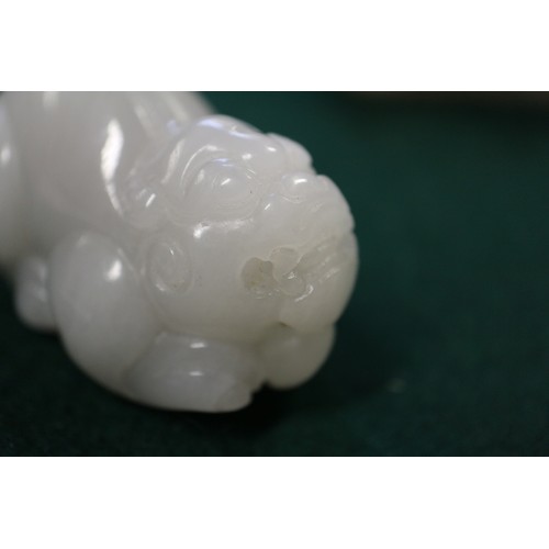 67 - A Chinese carved pale jade model of a mythical beast, 2 3/4