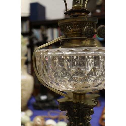 189 - An early 20th century brass oil lamp with Corinthian column and faceted clear glass reservoir, on sq... 