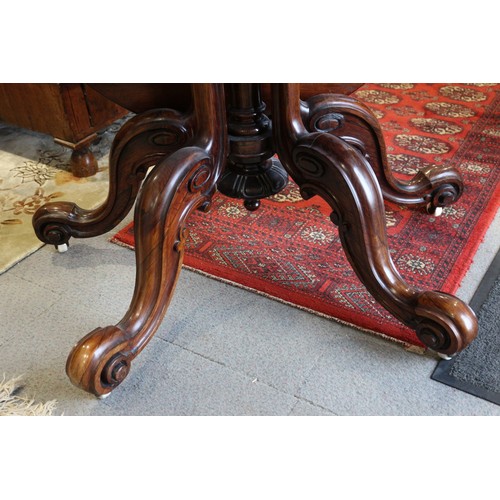 425 - A 19th century rosewood oval drop leaf table, on folding quadruple scroll supports, 36