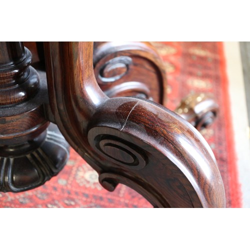 425 - A 19th century rosewood oval drop leaf table, on folding quadruple scroll supports, 36