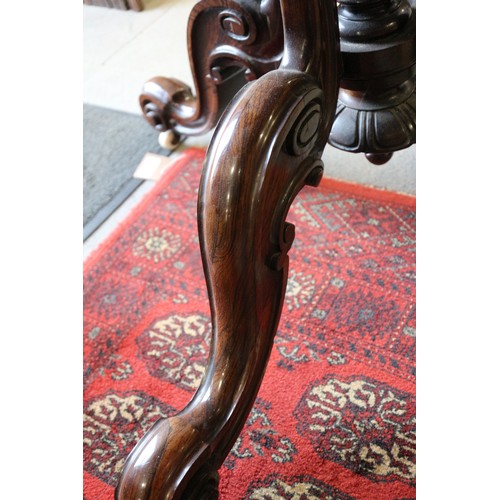 425 - A 19th century rosewood oval drop leaf table, on folding quadruple scroll supports, 36