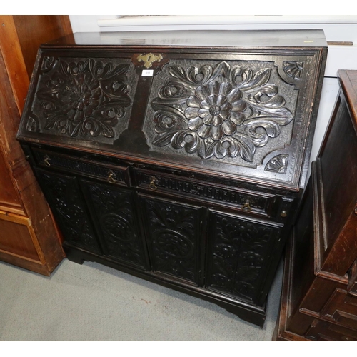 249 - A 19th century carved oak fall front bureau, the interior fitted drawers and pigeonholes, over two d... 