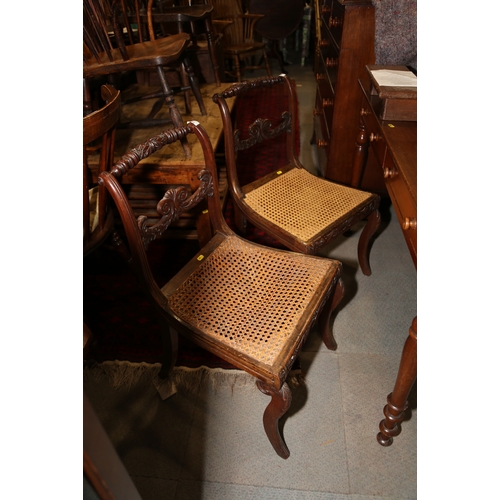 266 - A pair of early 19th century carved mahogany bar back side chairs with cane seats, on sabre leg supp... 