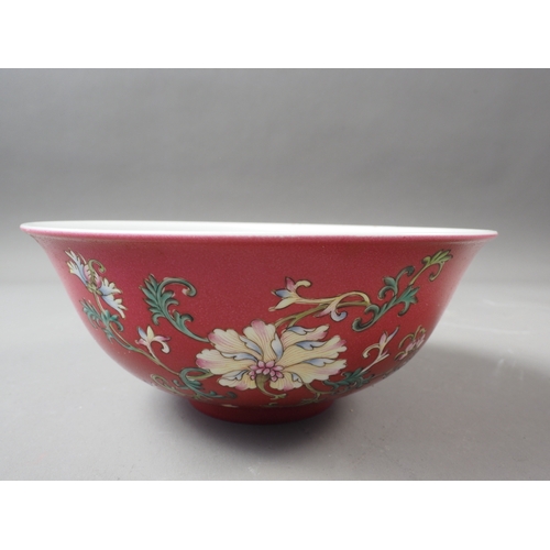 69 - A Chinese porcelain bowl with floral and scrolled decoration on a crimson ground, seal mark to base,... 