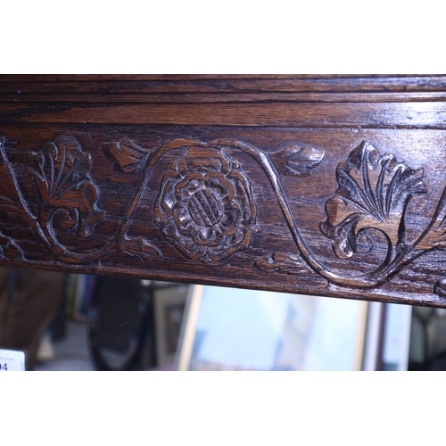 294 - A carved oak wall mirror with Tudor rose decoration, 36