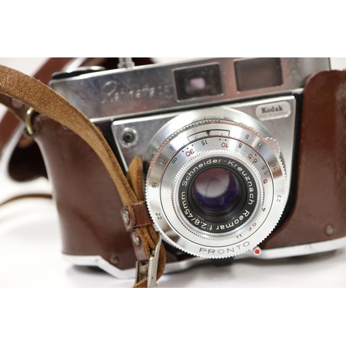 137 - A Voigtlander vest pocket camera and a Kodak camera, a brass preserve pan, a leather chest strap wit... 