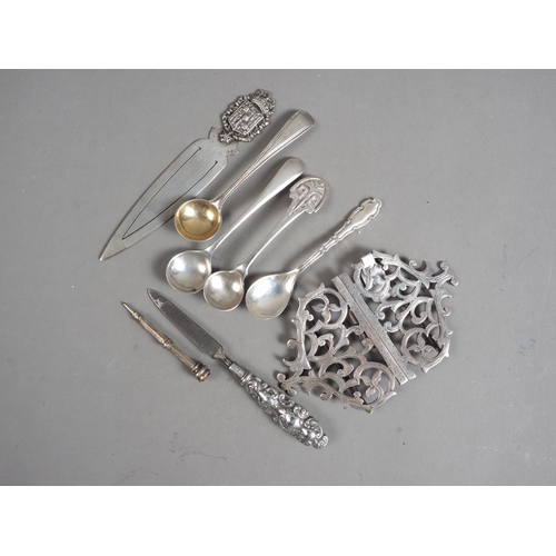 308 - Four silver condiment spoons, a nurse's silver buckle, a white metal book mark, a miniature propelli... 