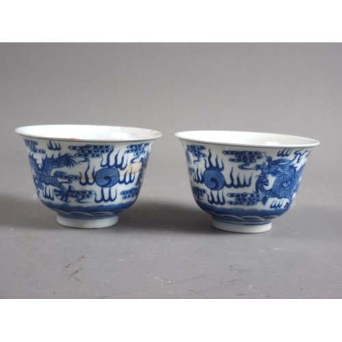 85 - A set of four Chinese porcelain blue and white bowls with flared rims, decorated dragons and clouds,... 