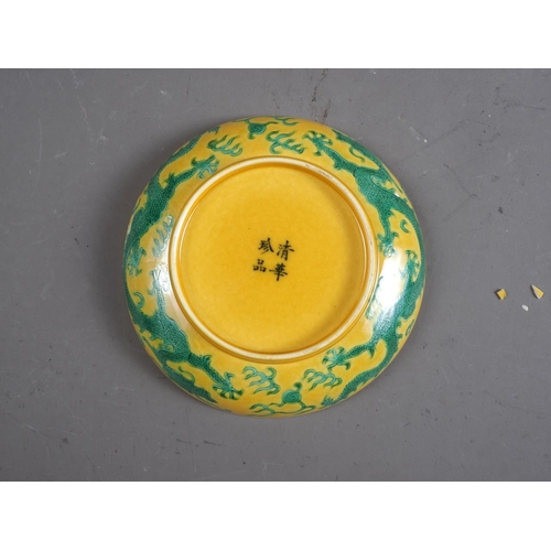 92 - A Chinese porcelain shallow dish, decorated dragons on a yellow ground, four-character mark to base,... 