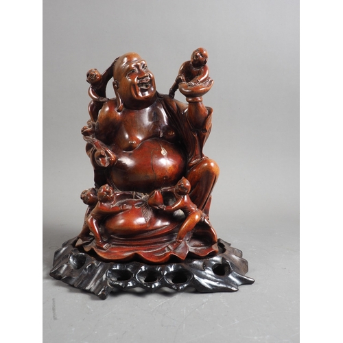 111 - A carved hardwood Hotei with children, 8