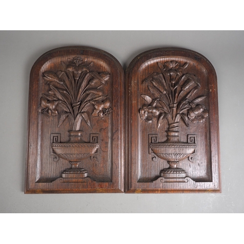 186 - A pair of oak floral vase carved arch top panels, 18