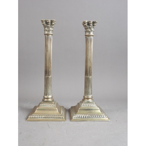 302 - A pair of silver plated Corinthian column candlesticks, on square bases, 12