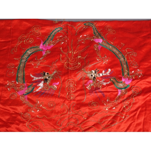 118 - An early 20th century Chinese embroidered panel with dragon design on a red ground