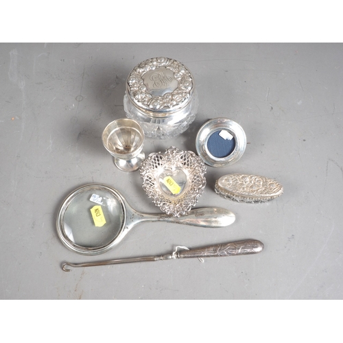 321 - Two cut glass silver mounted dressing table jars, a silver magnifying glass, a silver egg cup, a min... 