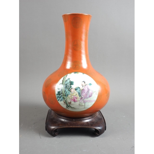 75 - A Chinese porcelain famille rose bulbous vase, decorated three panels of figures on an orange and gi... 