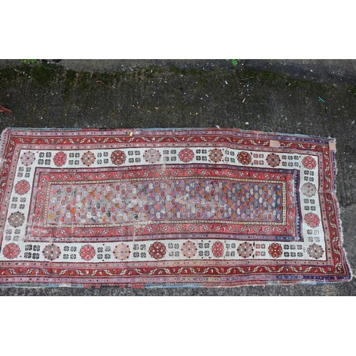 623 - An antique Caucasian rug with floral centre on a purple ground, 88