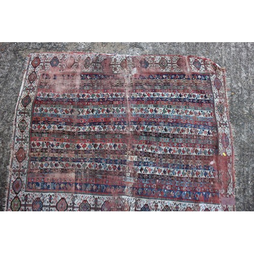 623 - An antique Caucasian rug with floral centre on a purple ground, 88