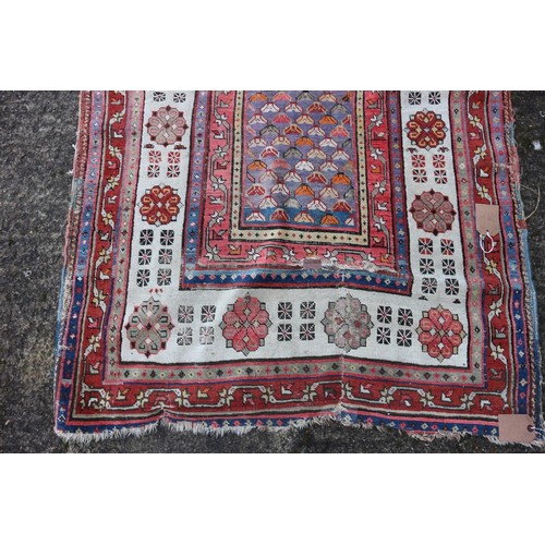 623 - An antique Caucasian rug with floral centre on a purple ground, 88