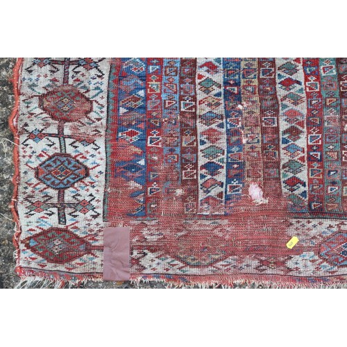 623 - An antique Caucasian rug with floral centre on a purple ground, 88