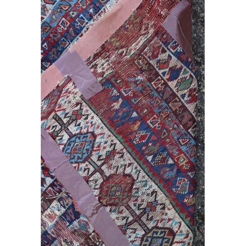 623 - An antique Caucasian rug with floral centre on a purple ground, 88