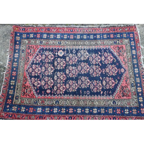 620 - A Caucasian rug with floral design, on a dark blue ground and triple bordered in shades of red, brow... 