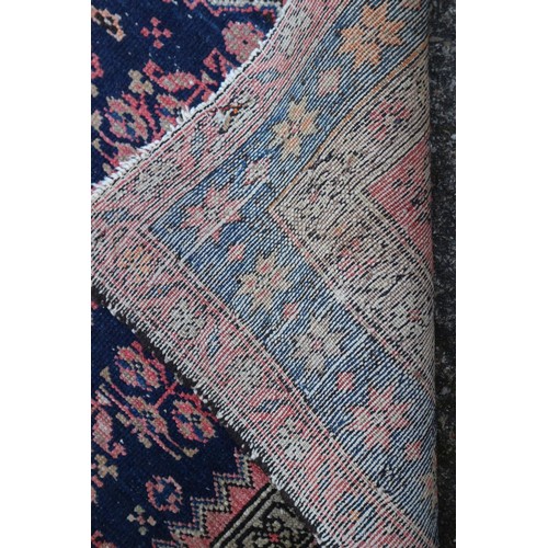 620 - A Caucasian rug with floral design, on a dark blue ground and triple bordered in shades of red, brow... 