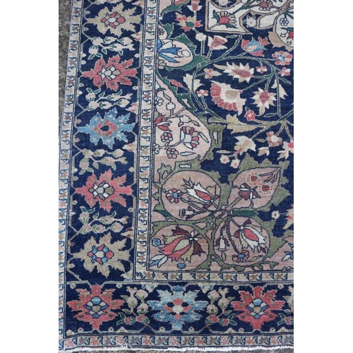 622 - A Persian city rug with all-over flower and scroll design, on a blue ground and multi-boarded in sha... 