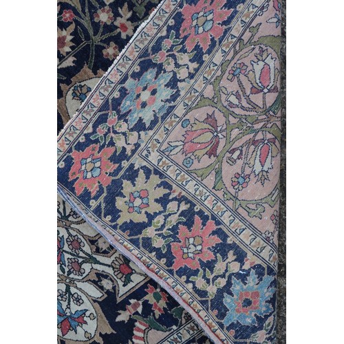 622 - A Persian city rug with all-over flower and scroll design, on a blue ground and multi-boarded in sha... 