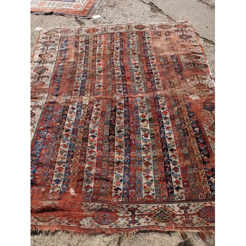 623 - An antique Caucasian rug with floral centre on a purple ground, 88