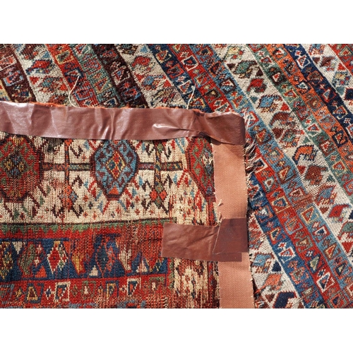 623 - An antique Caucasian rug with floral centre on a purple ground, 88