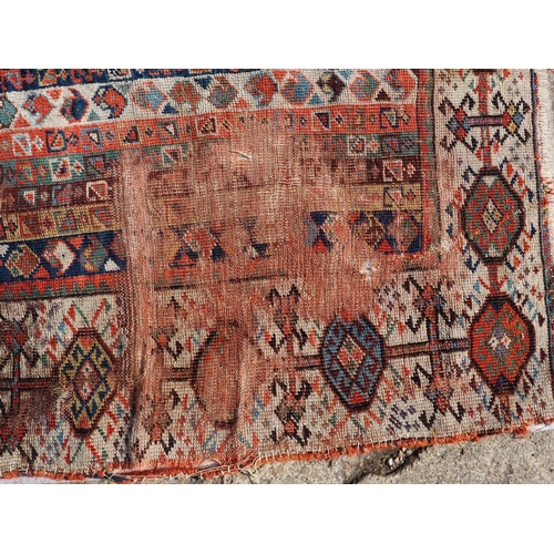 623 - An antique Caucasian rug with floral centre on a purple ground, 88