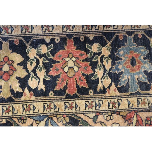 622 - A Persian city rug with all-over flower and scroll design, on a blue ground and multi-boarded in sha... 