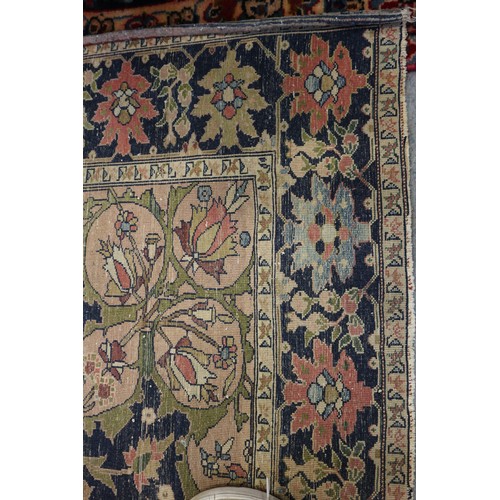 622 - A Persian city rug with all-over flower and scroll design, on a blue ground and multi-boarded in sha... 