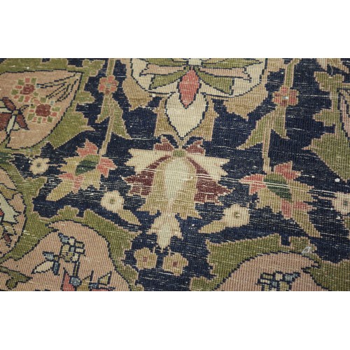 622 - A Persian city rug with all-over flower and scroll design, on a blue ground and multi-boarded in sha... 