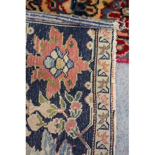 622 - A Persian city rug with all-over flower and scroll design, on a blue ground and multi-boarded in sha... 