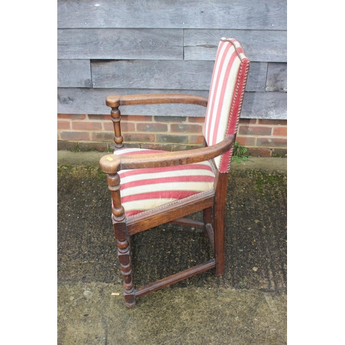 421 - An oak elbow chair of Restoration design with padded seat and back panels, on turned and stretchered... 