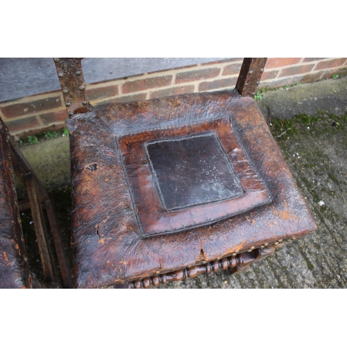 434 - A pair of 18th century oak chairs with seats and back upholstered in a brown leather, on turned and ... 