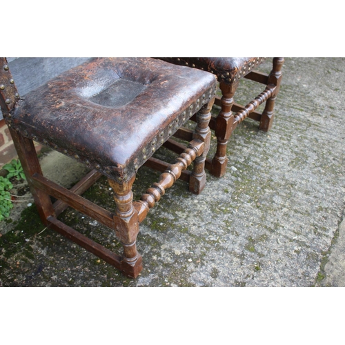 434 - A pair of 18th century oak chairs with seats and back upholstered in a brown leather, on turned and ... 